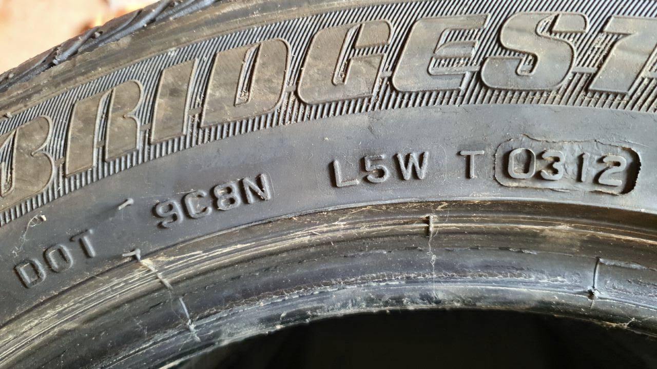 Close-up of a tire sidewall showing DOT marking and the final four date digits 0312